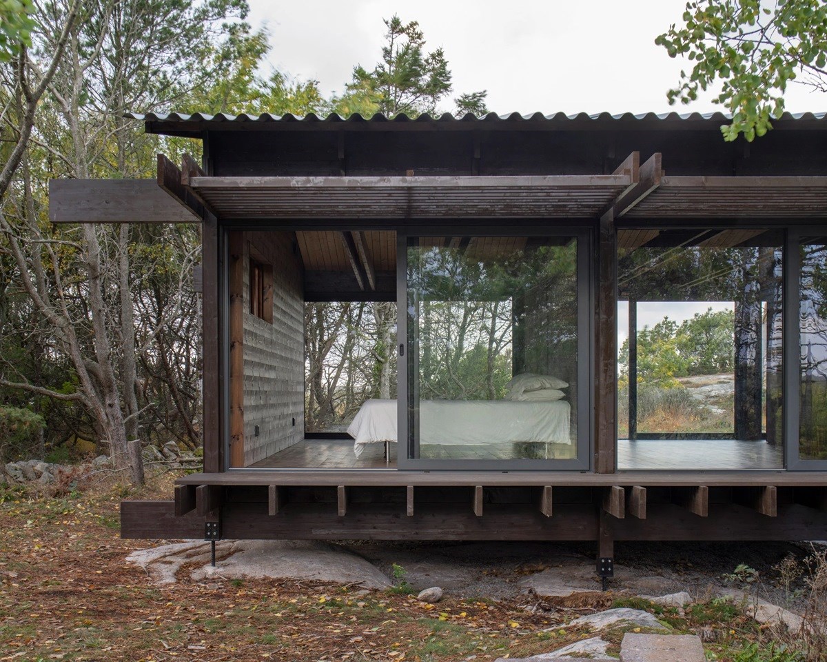 House Tjurpannan with Tar-Coated Black Timber Exterior by HelgessonGonzaga