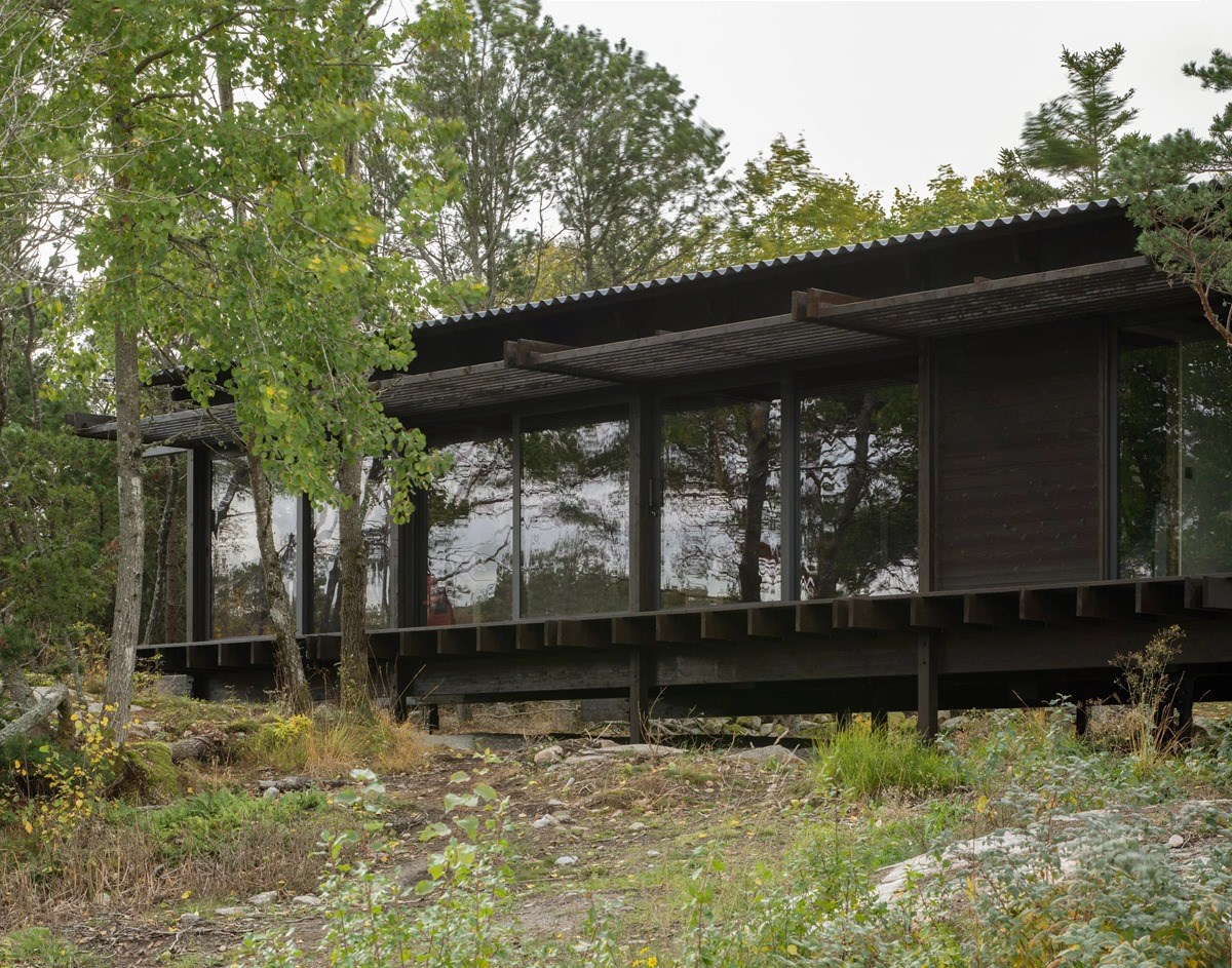 House Tjurpannan with Tar-Coated Black Timber Exterior by HelgessonGonzaga