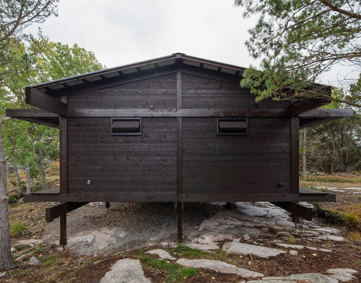 House Tjurpannan with Tar-Coated Black Timber Exterior by HelgessonGonzaga