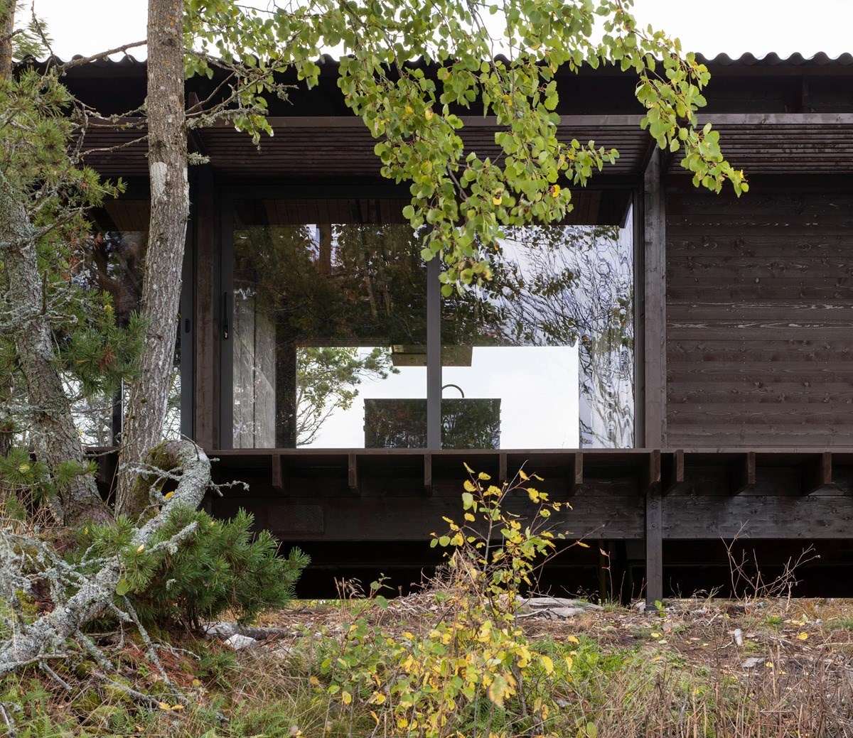 House Tjurpannan with Tar-Coated Black Timber Exterior by HelgessonGonzaga