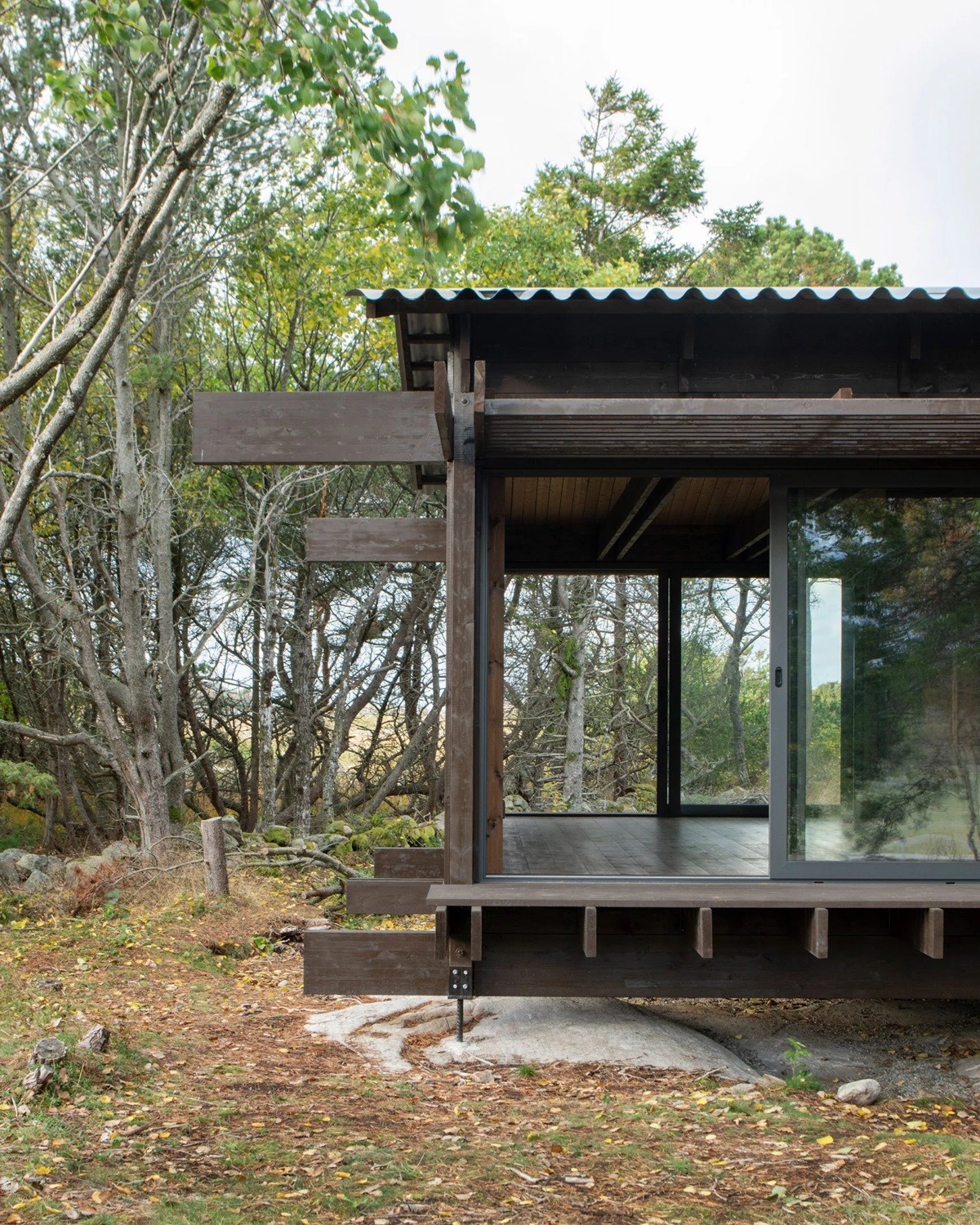 House Tjurpannan with Tar-Coated Black Timber Exterior by HelgessonGonzaga