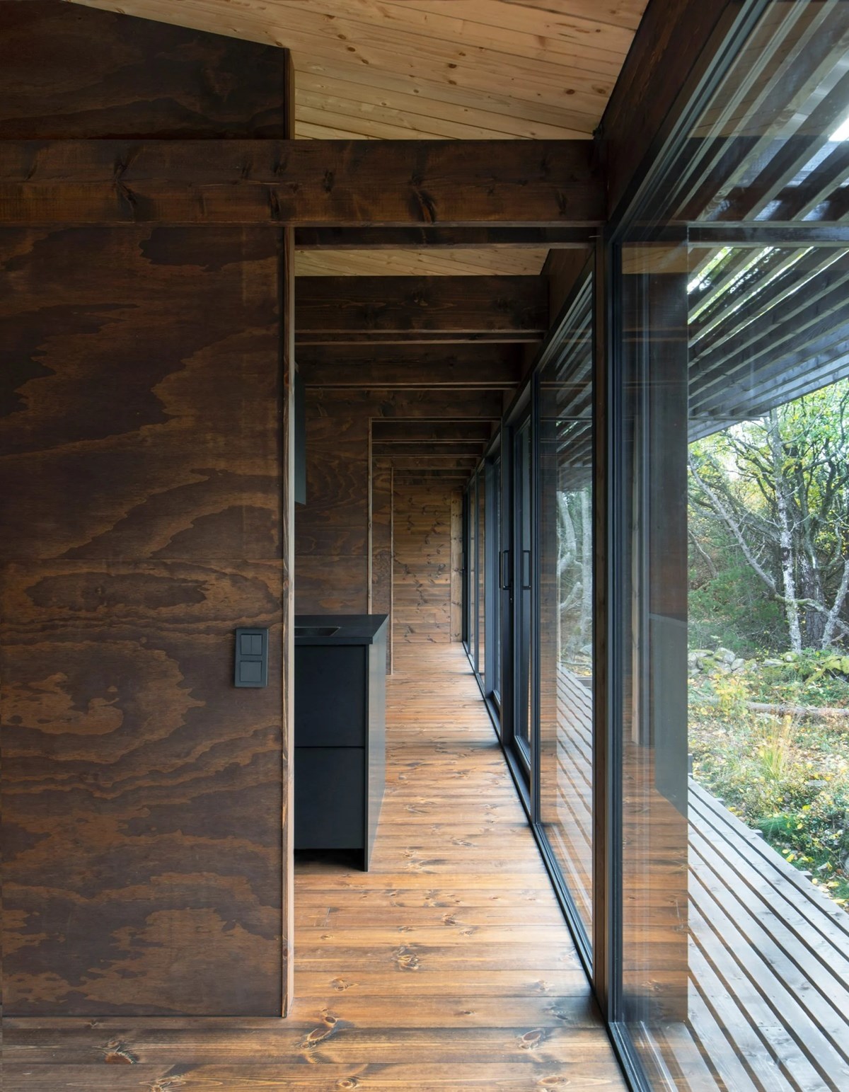 House Tjurpannan with Tar-Coated Black Timber Exterior by HelgessonGonzaga